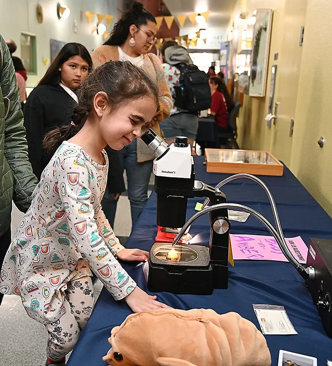 Margo Rubin, 5, squints to get a better look through the microscope. (Photo by Kathy Keatley Garvey)