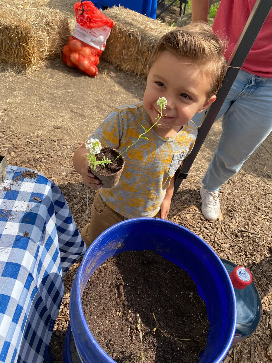 Child with plant at SBC Farm Day 2023