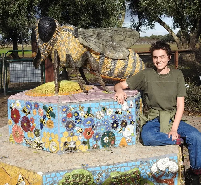 Michelle Monheit of Woodland stands by "Miss Bee Haven," sculpted by Donna Billick. Michelle has visited the garden since childhood when her mother was working on bee research. (Photo by Kathy Keatley Garvey)