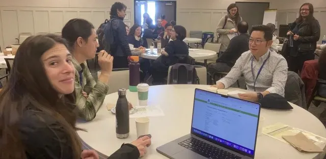 People sitting at a table smiling for the photo.