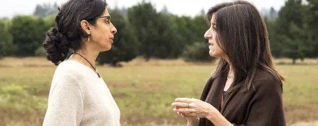 Employees conversating in an open field.