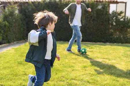 Father and son playing with soccer ball