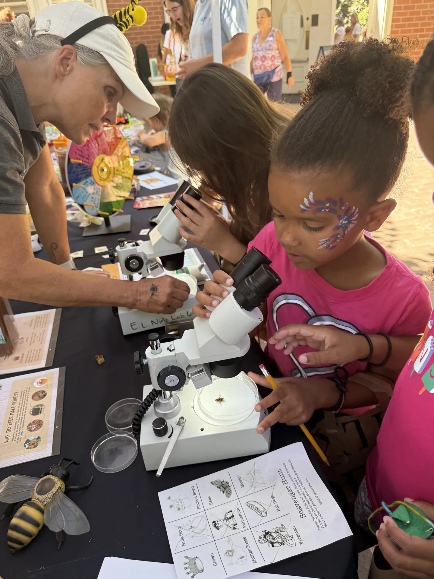 Wendy Mather, co-program manager of the UC Davis-based California Master Beekeeper Program, staffs the microscope table. Six-year-old Addison loved the microscopes and the bees.