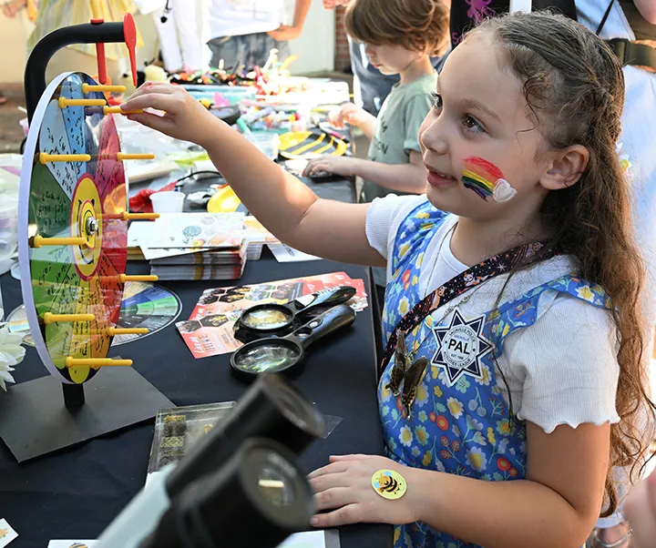 Amelia Vasquez-Fuller, 6, of Vacaville, spins the wheel. She answered the question correctly and received a prize. (Photo by Kathy Keatley Garvey)