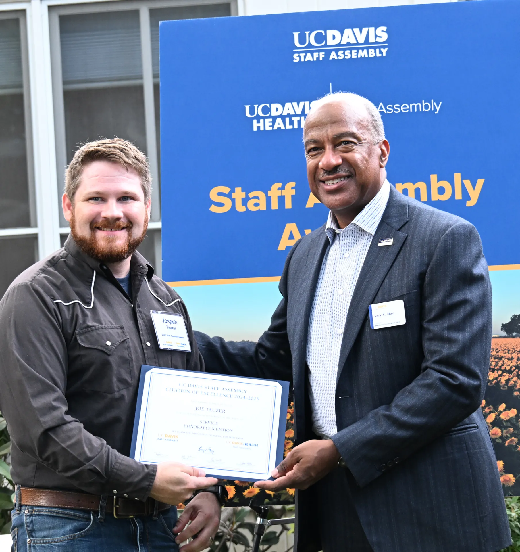 Joseph Tauzer, manager of the Harry H. Laidlaw Jr. Honey Bee Research Facility, receives congratulations from UC Davis Chancellor Gary May. (Photo by Kathy Keatley Garvey)
