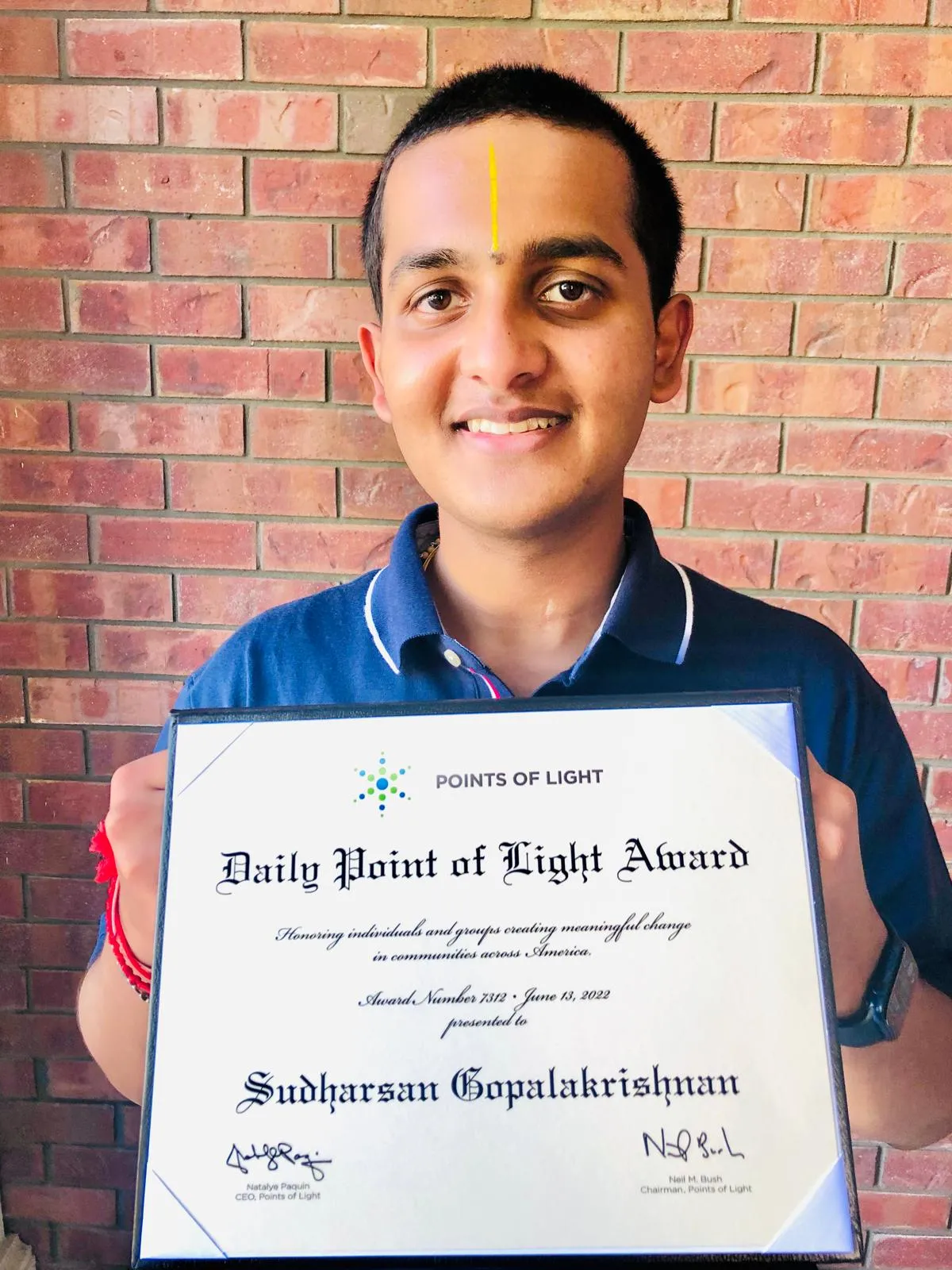 Sudy holding his Daily Point of Light award