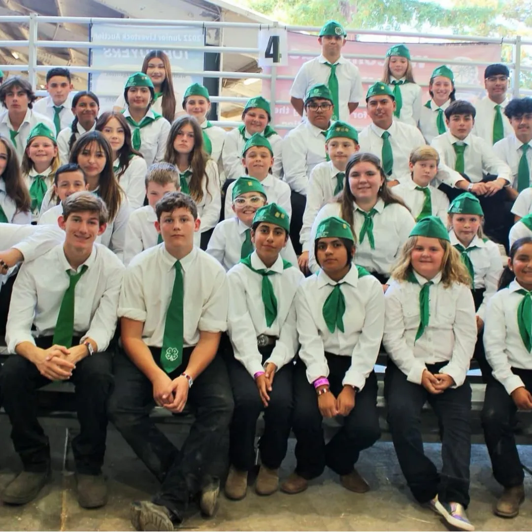 Picture of many kids wearing white shirts and the 4-H hat and tie. 