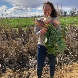 this is a photo of Sarah Light holding a turnip. 