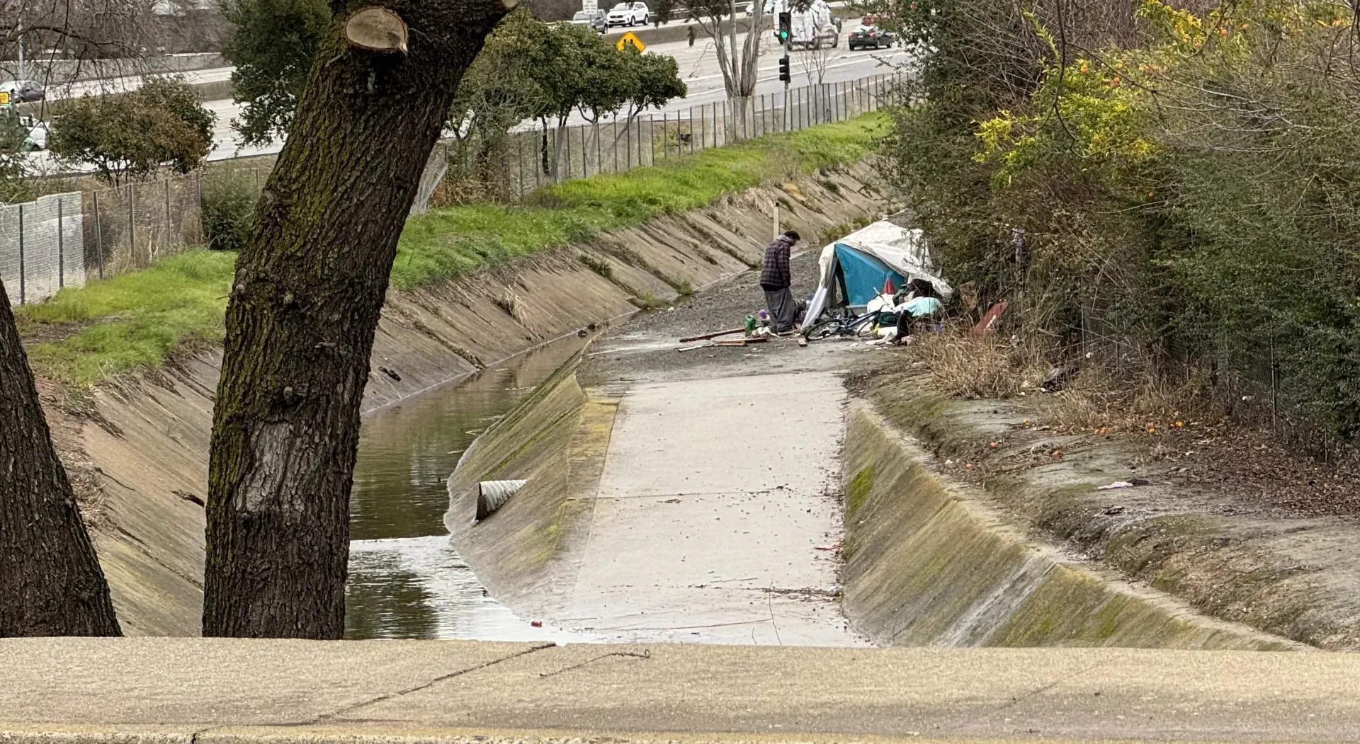 Tienda de campaña de una persona desamparada en la orilla de un arroyo.