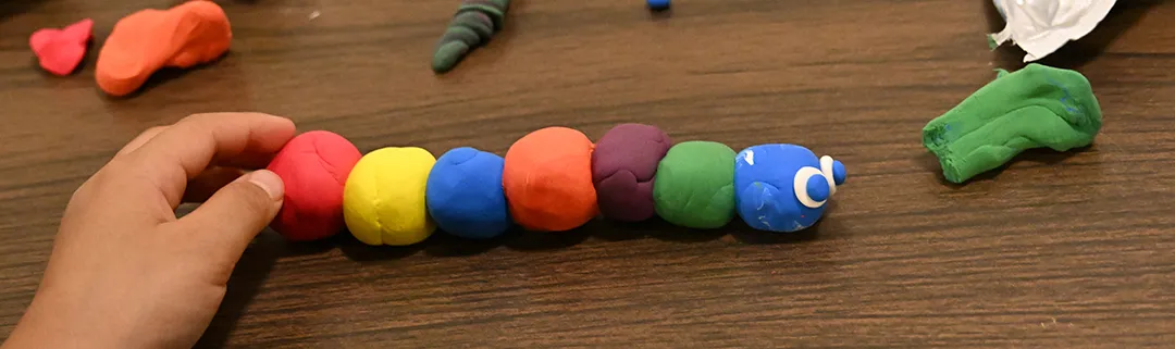 Colorful modeling clay turned into a caterpillar, with a coat of many colors. 