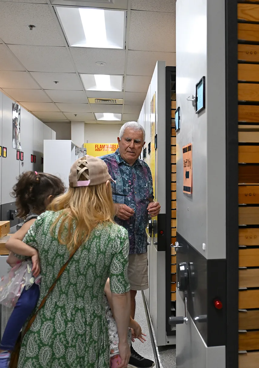 Jeff Smith, curator of the Lepodoptera collection, greets a family.
