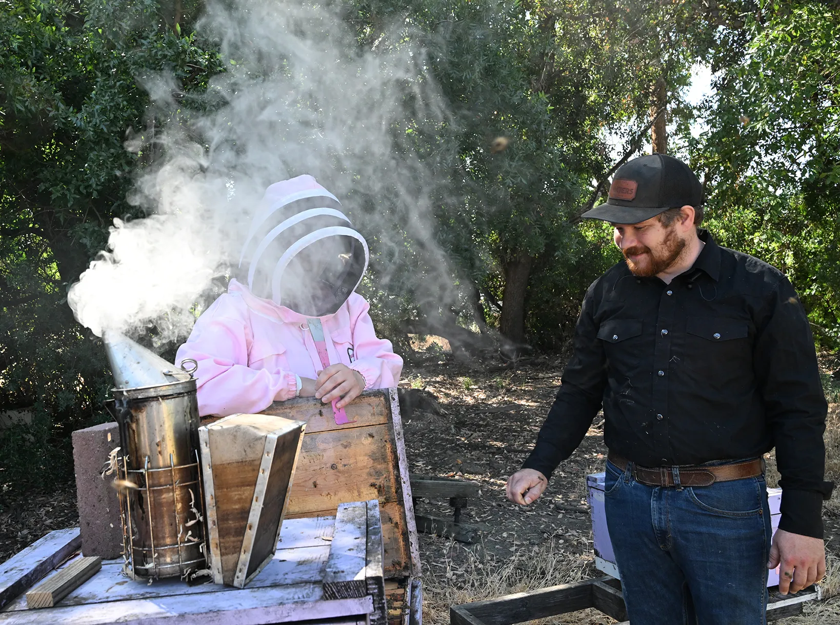 Professor and bee scientist Elina Lastro Niño and Joe Tauzer, manager of the Harry H. Laidlaw Jr. Honey Bee Research Facility, working in the apiary.