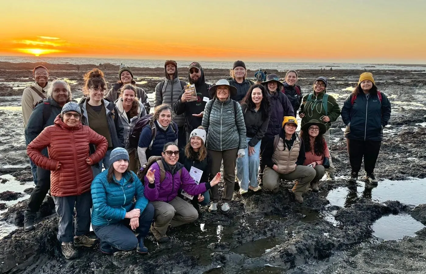 Grupo de asistentes al curso de naturalistas posa frente al mar.
