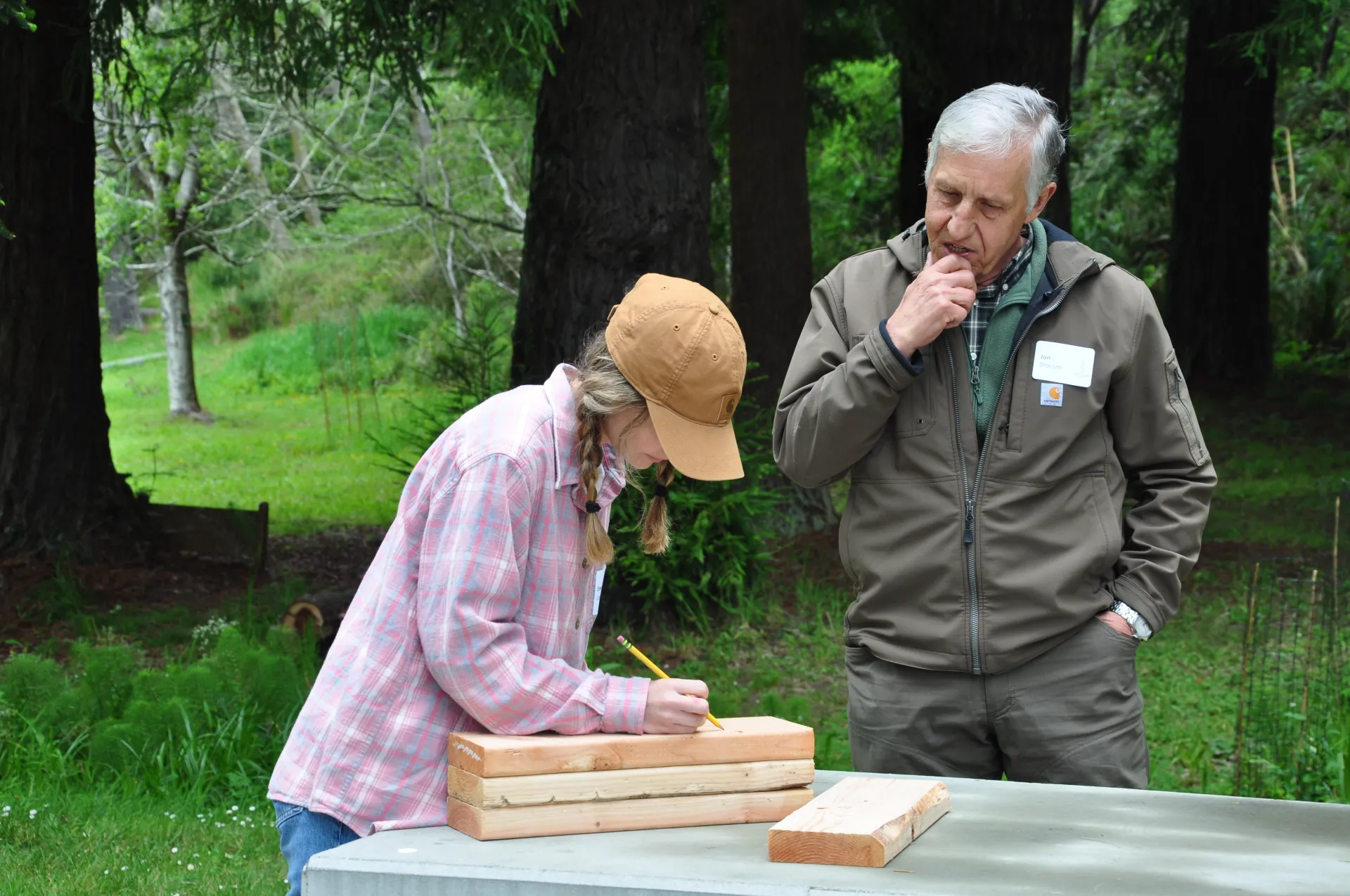 Two people mark wood panels for during a Mass Timber class at CA Tree School.