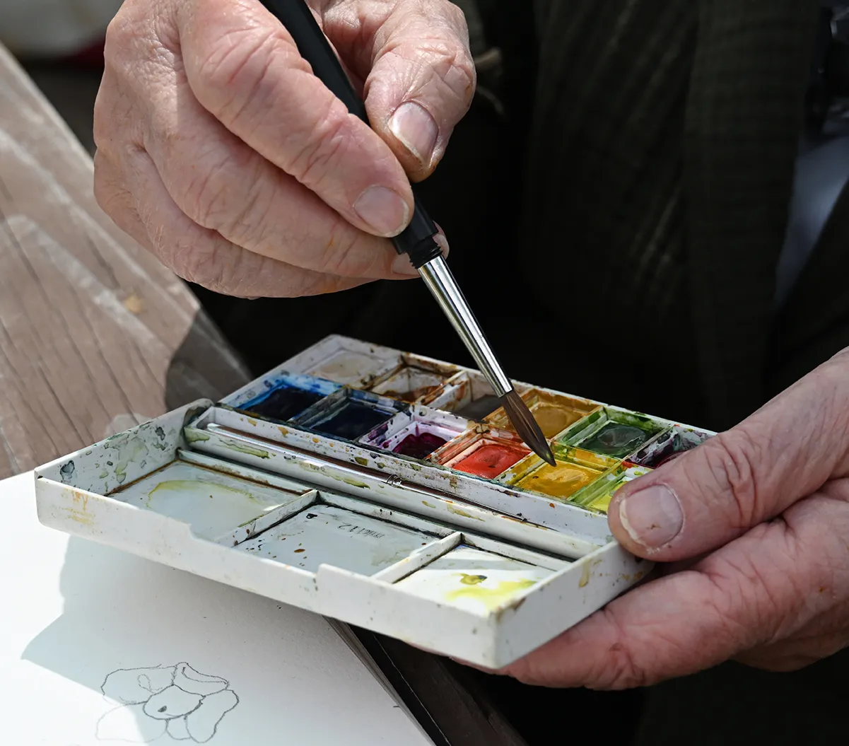 Close-up of hands of Lori Topinka with paint brush.