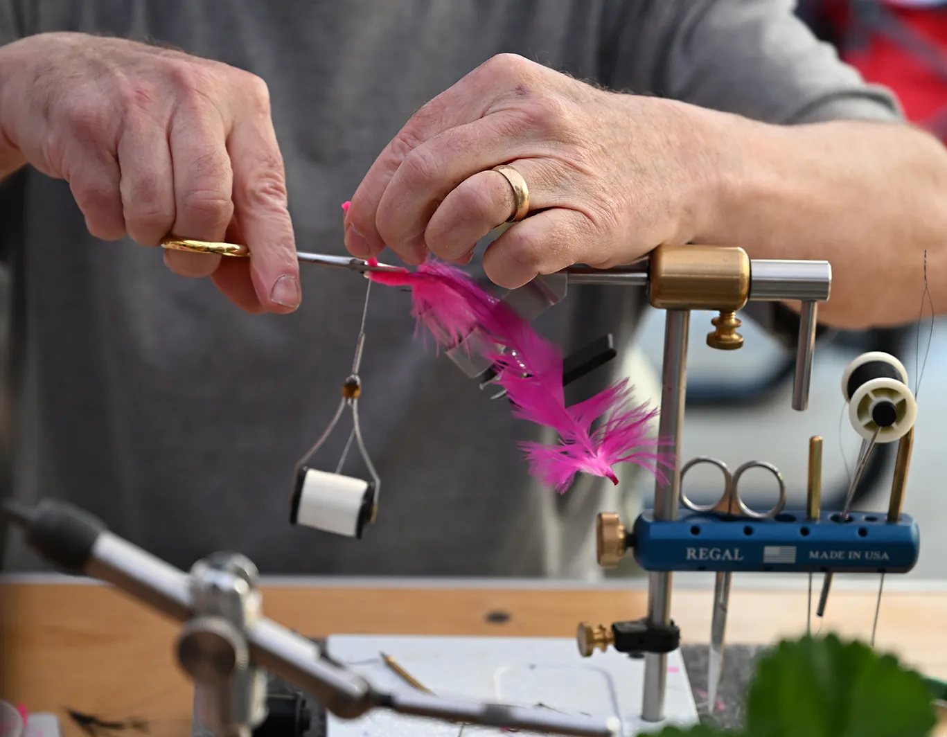 Expert hands of a member of the Fly Fishers of Davis tying a fly at UC Davis Picnic Day