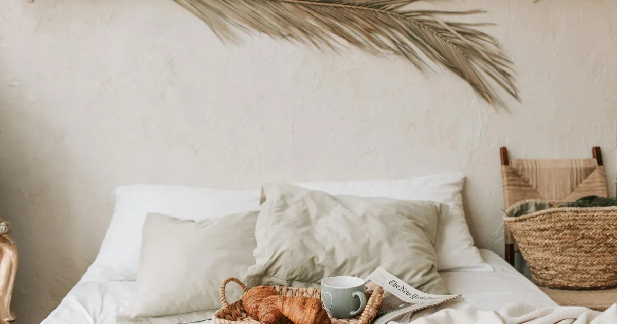 hotel bed with breakfast and newspaper
