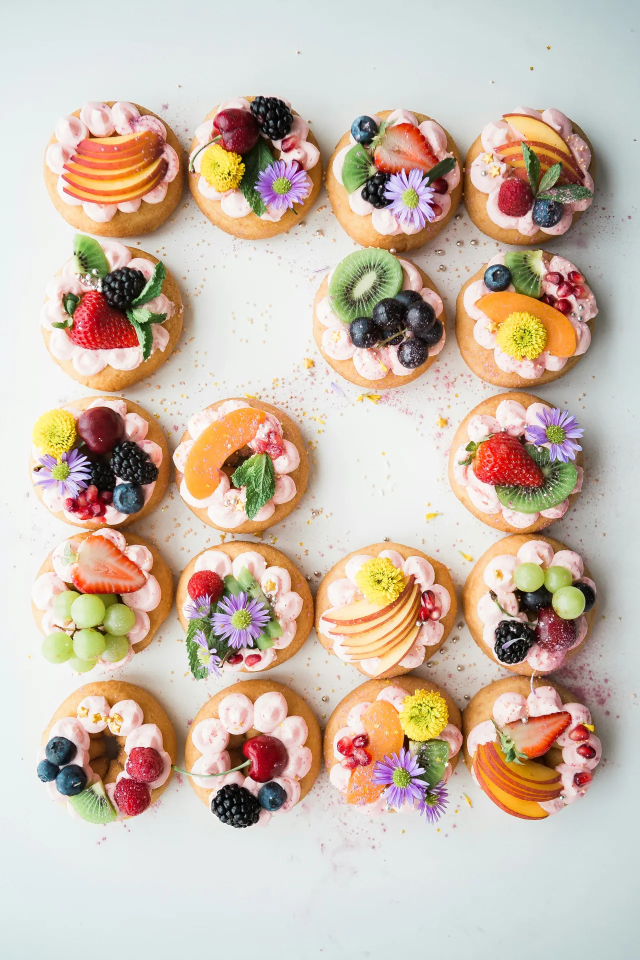 Cookies topped with fruits and flowers.