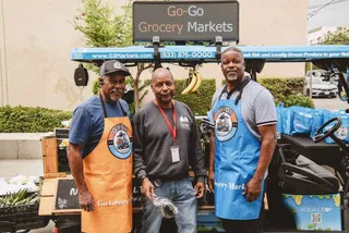 Southwest Regional Food Business Center clients standing in front of a new cart for their co-op grocery store.