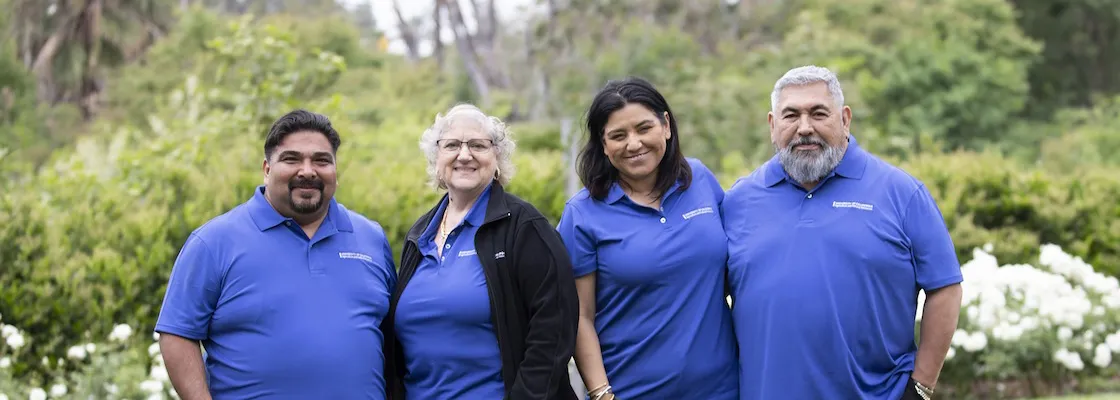 Four people smiling and wearing blue UC ANR shirts