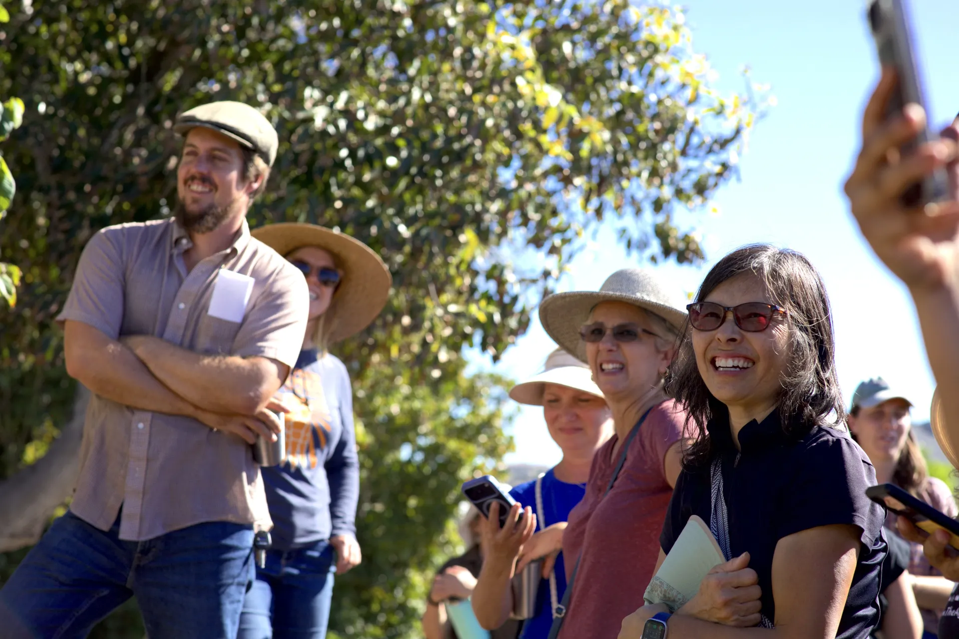 People smiling outside on a farm