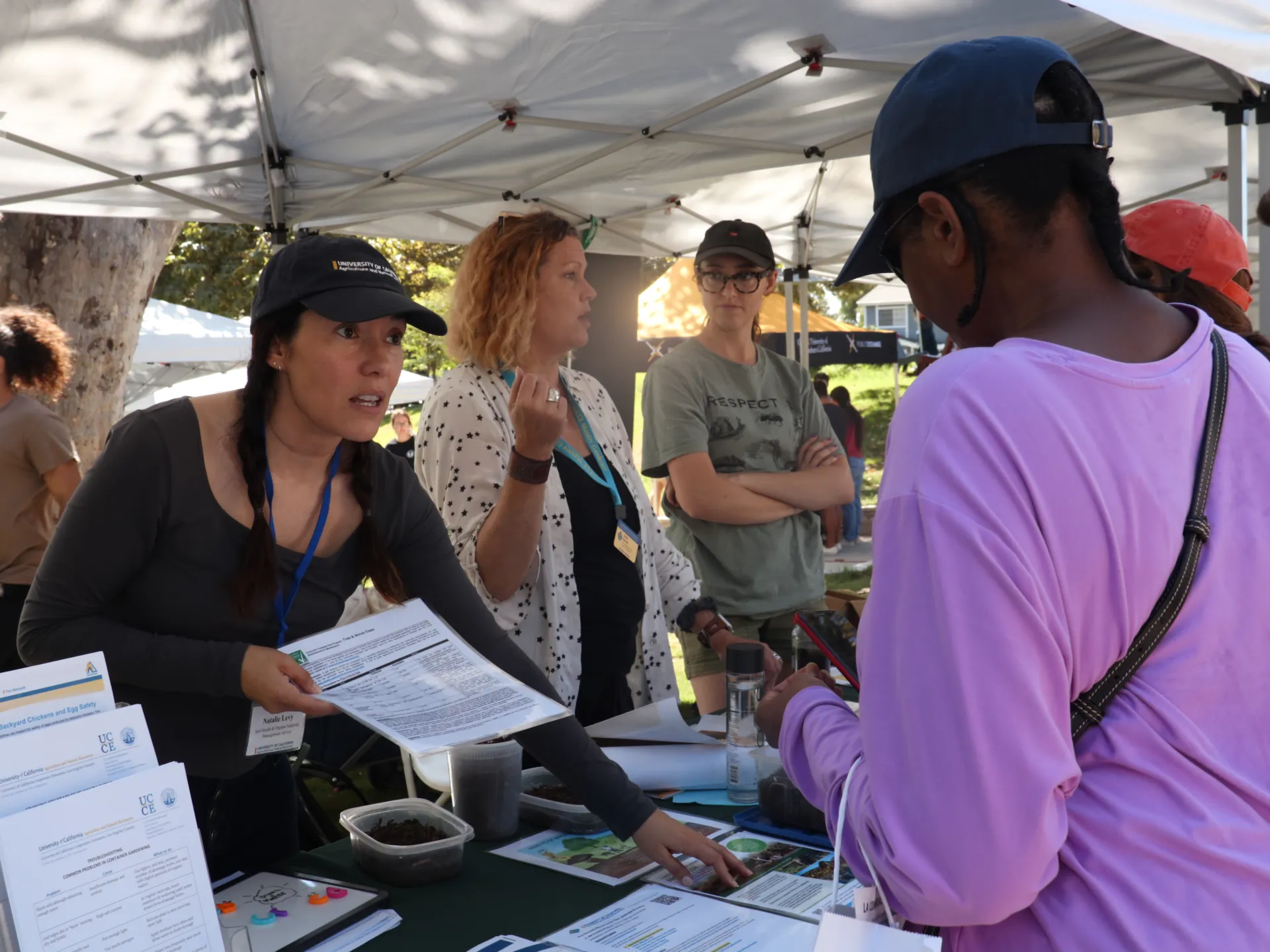 A woman tabling offers information about compost