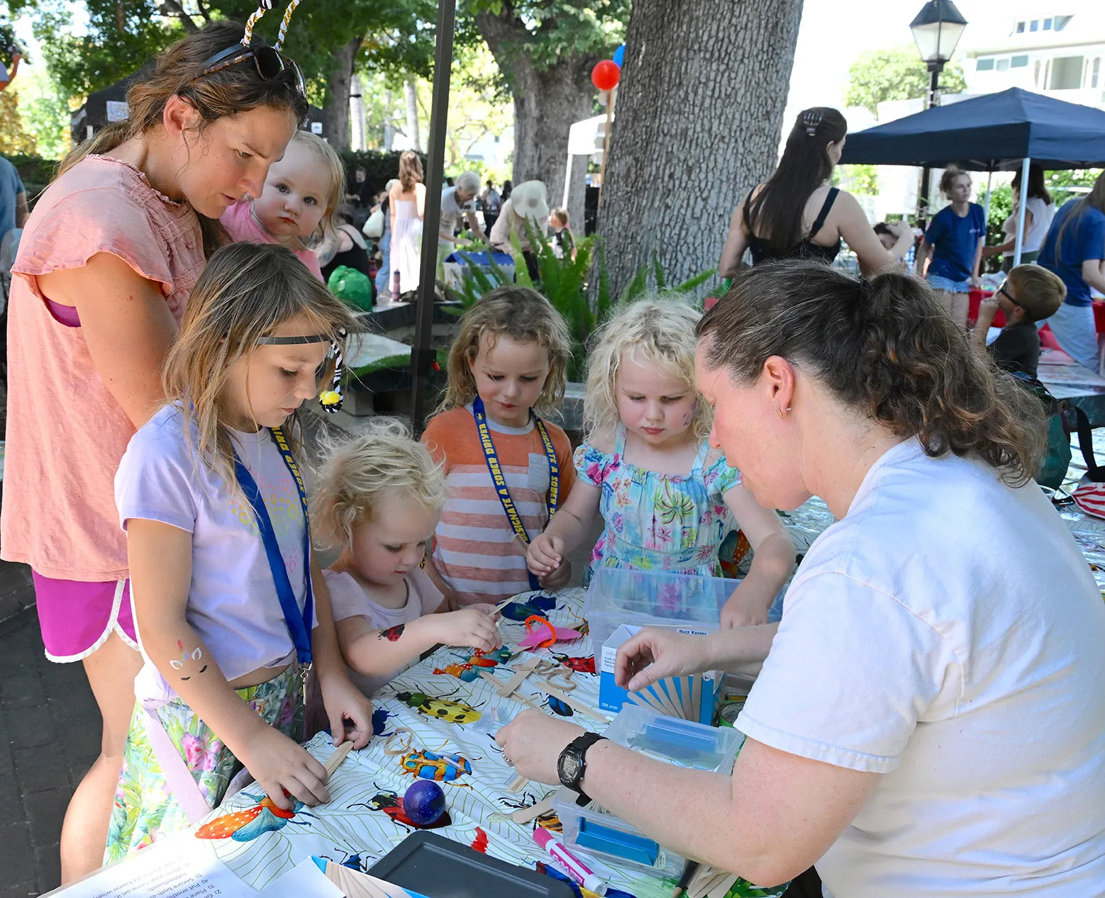 Tabatha Yang showing Rusert family how to make buzz kazoos