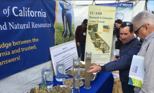 World Ag Expo visitors discuss conservation tillage at Jeff Mitchell's exhibit at the UC ANR tent.