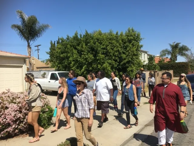 Deron White (al centro, en playera blanca) especialista en difusión comunitaria de OVGG, acompaña a los miembros de GFI durante un recorrido por su vecindario. “Empecé a participar con el huerto para poder ser un enlace con mi comunidad”, dijo White. Tenía que haber una aceptación de la comunidad hacia el huerto, así que es algo en lo que yo ayudé. Ahora el huerto es un espacio en el que podemos reunirnos y crear vínculos”.