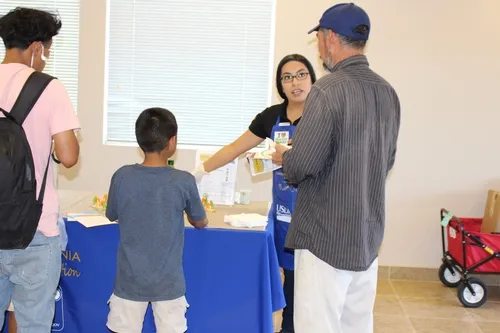 Community members visit the information booth to learn about choosing healthy snacks