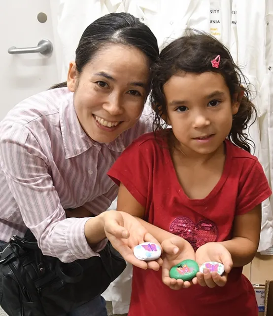 Winters residents Machiko Murdock and her daughter, Lilah Murdock, 5, display their rocks. Machiko works in the lab of Christian Nansen, UC Davis Department of Entomology and Nematology. (Photo by Kathy Keatley Garvey)