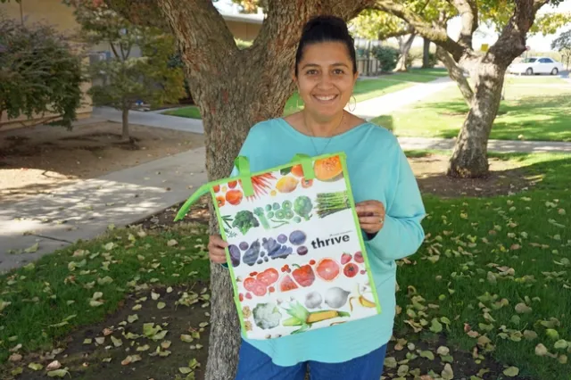 The Staff Assembly Ambassador for the Kearney Research and Extension Center, Emily Casado, shows the insulated bag that the first 100 registrants to the UC ANR Maintain Don't Gain Challenge will receive.