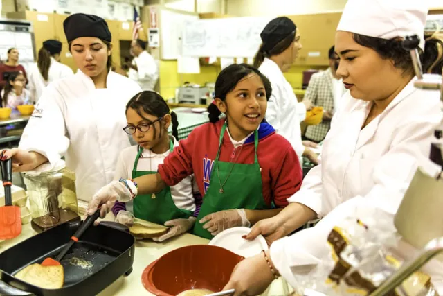 Elementary school students learn from 4-H teens how to cook healthy meals. (Photo used with permission.)