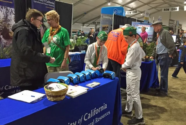 From left, Liz Sizensky of UC Nutrition Policy Institute, and Julie Sievert, assistant KARE program and facility coordinator, assist 4-H members with virtual reality goggles.