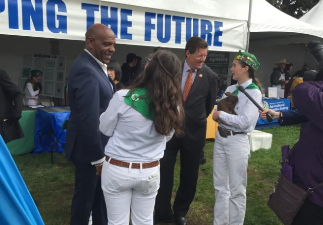 State Senators Steven Bradford and Brian Jones talk with members of California 4-H about rabbits.