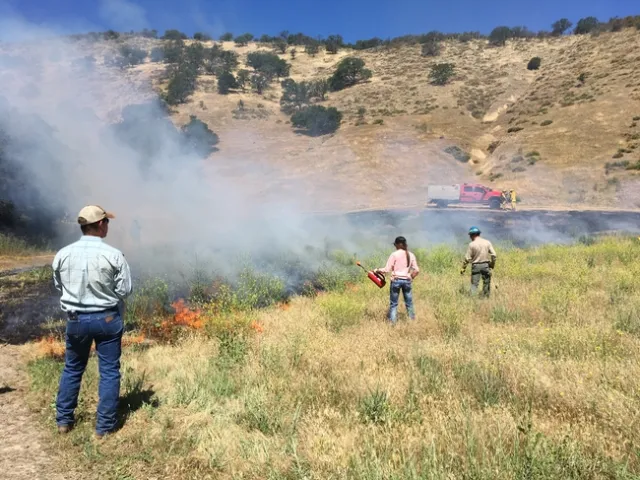 Workshop participant learning how to use a drip torch.