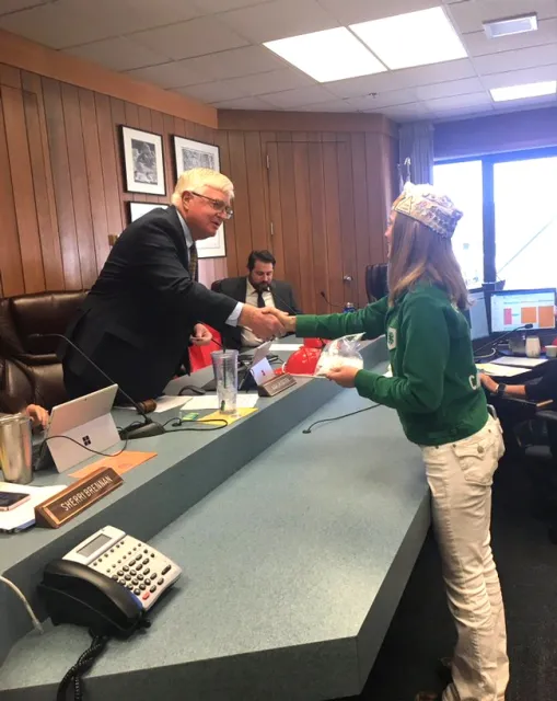 Board Chair, Supervisor Karl Rodefer shaking the hand of Belle, Tuolumne County Ambassador