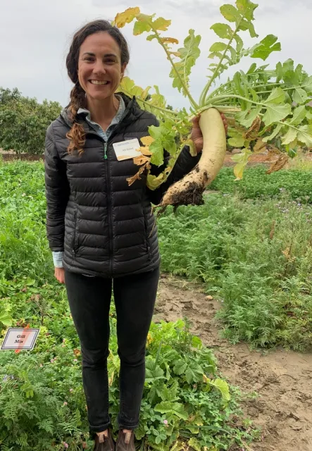 Alli holding a daikon radish.