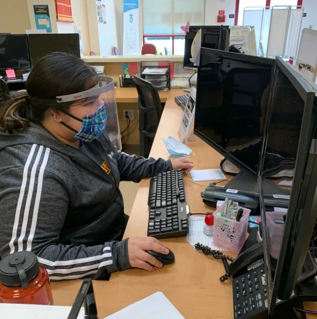 Health care worker with face shield at computer