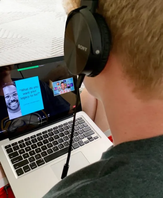 Youth with headphones looking at presentation on laptop screen