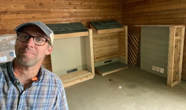 Ryan Tompkins shown with walls he built to demonstrate how fire moves on home construction.