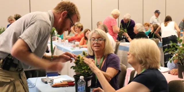 Attendees at a UC Master Gardener traiing looking at a plant