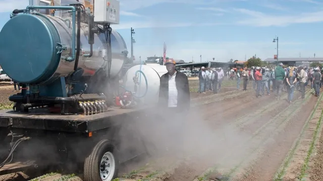 Postdoctoral researcher Connel Ching'anda stands by a machine that uses steam to disinfect soil of pathogens that can harm leafy green crops. Steve Fennimore and his team, of the UC Davis Department of Plant Sciences, tested the equipment last year in Salinas fields, and they demonstrated its use during Automated Technology Field Day, also in Salinas, in June. (Photo courtesy Jeffrey Mitchell/UC Davis)