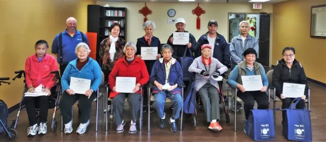 A group of older adults and their instructor pose for a photo celebrating their completion of a six-week workshop series called Eat Healthy, Be Active.