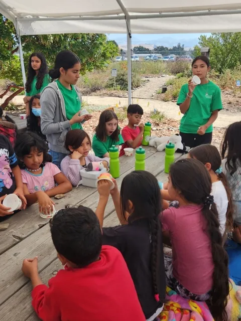 Consejeros adolescentes y campistas trabajan en una actividad sobre nutrición.