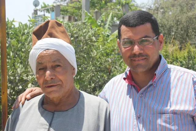 A father and son pose for a photograph