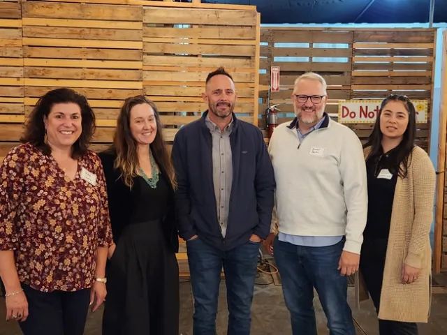 Five people standing in a row.