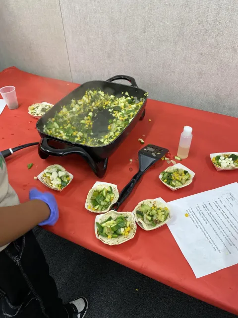 Student plating vegetable sauté after cooking activity