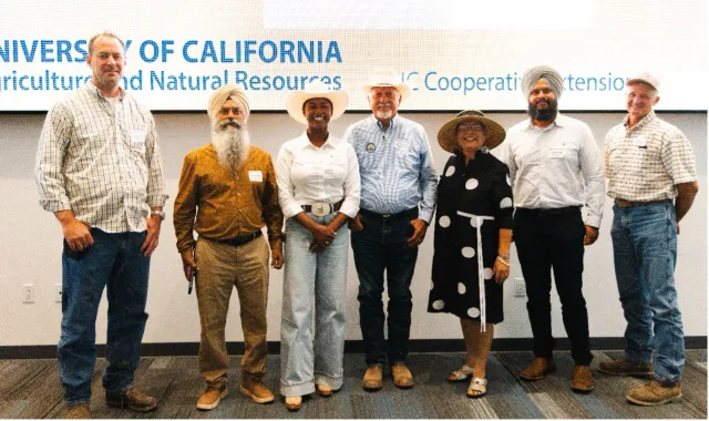 Seven farmers stand in a row