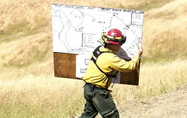Firefighter carrying map in a field